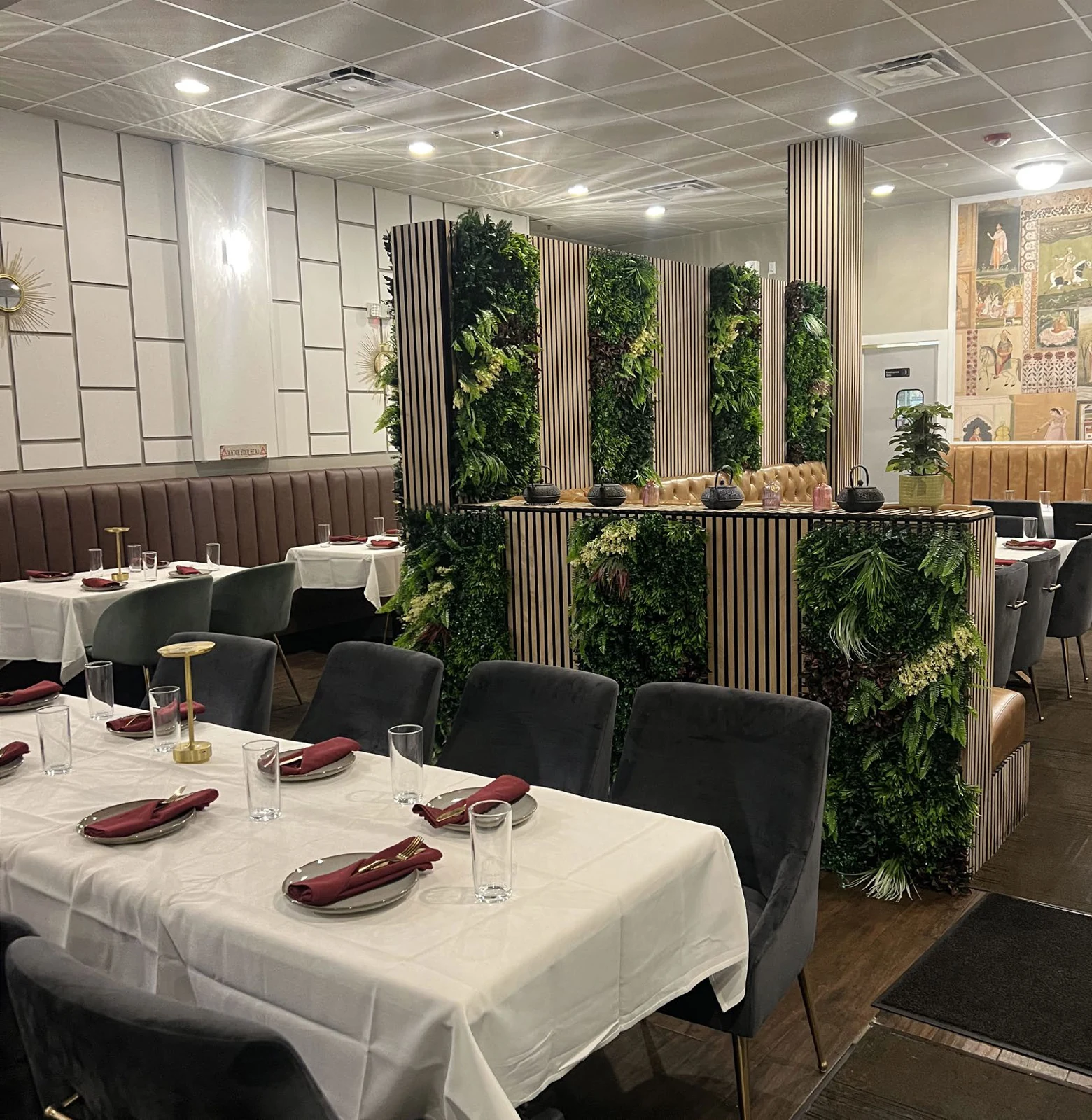 Dining room with upholstered seating and greenery from the Tamara Cuisine magazine feature